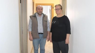 Görme engelli Necmettin Emekçi ile eşi Fidan Emekçi evlerinin koridorunda yan yana ayakta bulunuyor.