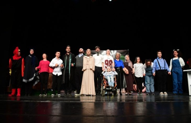 Osmangazi Belediyesi Engelli Tiyatro Ekibi oyun sonunda sahnede yan yana bulunuyor.