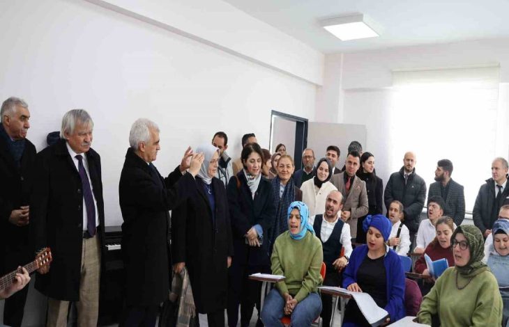 TBMM Engelli Bireylerin Sorunlarını Araştırma Komisyonu üyeleri ayakta, oturarak şarkı söyleyen koroyu dinliyor.