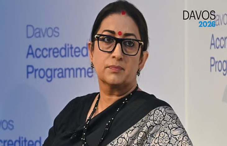 Siyah sari giymiş, gözlüklü bir kadın sahnede konuşma yaparken görülüyor. Arka planda “Davos Accredited Programme” yazıları yer alıyor.