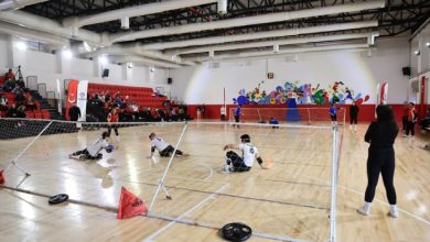 Kapalı spor salonu sahasında goalball maçı oynanıyor.