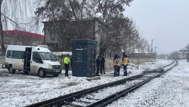 Karlı demiryolu hattı üzerinde, güvenlik görevlileri ve resmi ekiplerin bir olay nedeniyle rayların yanında toplandığı, rayların üstünde engelliye ait bedenin bulanıklaştırıldığı görülüyor.