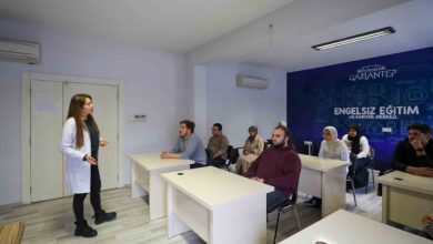 Görme engelli öğretmeni Hilal Şimşek ayakta bulunarak, sıralarda oturan kursiyerlere ders anlatıyor.