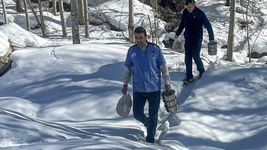 Karlı arazide ilerleyen iki görevli, termos ve poşetlerle sıcak yemekleri özel gereksinimli ve yaşlıların evlerine ulaştırmak için yol alıyor.