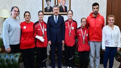 Eskişehir Valisi Dr. Erdinç Yılmaz, işitme engelli taekwondo sporcular ve antrenörler ile yan yana ayakta durarak poz veriyor.