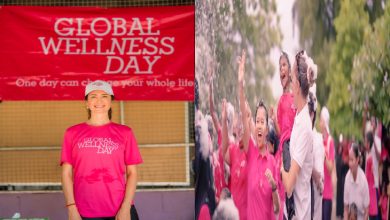 İki kareden oluşan görselde pembe temalı bir etkinlik atmosferi var. Sol tarafta, üzerinde “Global Wellness Day” yazılı pembe tişört giyen bir kadın, aynı ifadeyi taşıyan kırmızı bir pankartın önünde gülümsüyor. Sağ tarafta ise yine pembe tişörtler giymiş kalabalık bir grup açık alanda coşkuyla ellerini kaldırmış; enerjik ve kutlama havasında bir etkinlik anı yansıtılıyor.