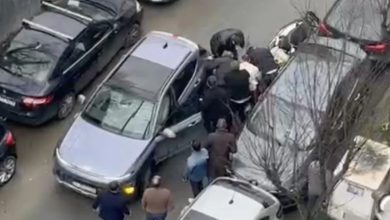 Dar bir sokakta trafiğe sıkışmış araçların arasında bir grup erkek kavga ediyor. Arabaların kapıları açık, çevredeki kişiler araya girmeye çalışıyor. Olay yukarıdan, bir binadan çekilmiş gibi görünüyor.