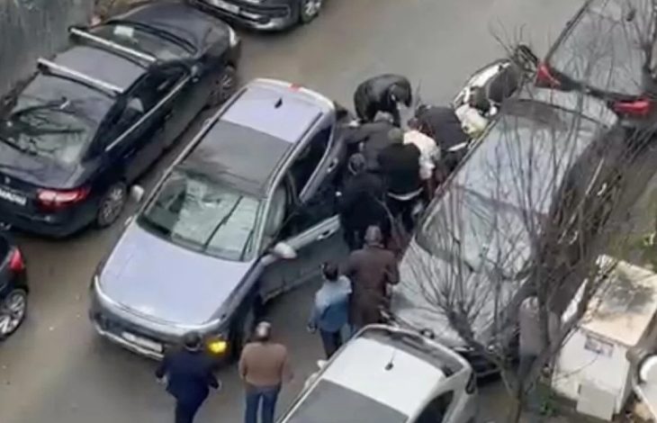 Dar bir sokakta trafiğe sıkışmış araçların arasında bir grup erkek kavga ediyor. Arabaların kapıları açık, çevredeki kişiler araya girmeye çalışıyor. Olay yukarıdan, bir binadan çekilmiş gibi görünüyor.