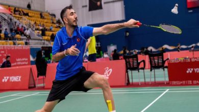 Milli para sporcu İlker Tuzcu raketiyle badminton topuna vuruşunda dizlerinin üstünde duruyor.