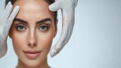 Fotoğrafta, açık renk bir arka plan önünde, doğrudan kameraya bakan genç bir kadının yüzü yakın plandan görülüyor. Kadının cildi pürüzsüz ve aydınlık; kaşları belirgin, gözleri açık renkli. Saçları geriye doğru toplanmış, yüz hatları net biçimde ortaya çıkıyor.