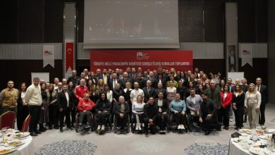 Türkiye Milli Paralimpik Komitesi yöneticileri ile paralimpik sporcular toplantı salonunda poz veriyor.