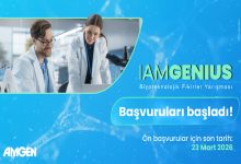 Mavi tonların hâkim olduğu afişte, Amgen tarafından düzenlenen “IAMGENIUS Biyoteknolojik Fikirler Yarışması” tanıtılıyor. Laboratuvarda çalışan iki araştırmacının görseli eşliğinde “Başvurular başladı!” mesajı öne çıkıyor ve son başvuru tarihi olarak 23 Mart 2026 belirtiliyor.