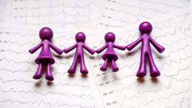 Görselde, mor renkli figürlerden oluşan bir aile sembolü (anne, baba ve iki çocuk) el ele tutuşmuş halde yer alıyor. Figürlerin altında ise beyin dalgalarını gösteren EEG çıktıları bulunuyor. Görsel, epilepsiyle yaşayan çocuklar ve ailelerinin dayanışmasını ve farkındalık mesajını simgeliyor.