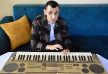 Engelli müzisyen Murat Coşkun, koltukta oturarak org çalıyor.