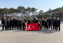 Para Yüzme Dünya Serisi'ne katılan milli sporcular ile teknik heyet, açık bir alanda süs havuzu önünde Türk bayrağı açarak poz veriyor.