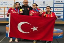 Özel para atletler Fatma Damla Altın ve Esra Bayrak, erkek ve kadın antrenörleriyle birlikte Türk bayrağı tutarak poz veriyorlar.