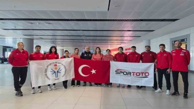 Özel Sporcular Para Atletizm Milli Takımı, teknik kadro ile TÖSSFED ve Spor Toto logolu bayrağı tutuyorlar.