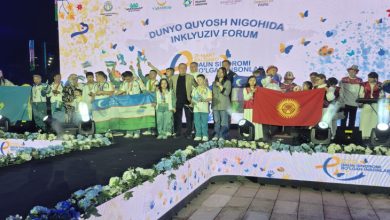 Türk Devletleri Özel Sporcular Festivaline katılan sporcular ile yöneticiler sahnede ülke bayraklarını açarak poz veriyor.