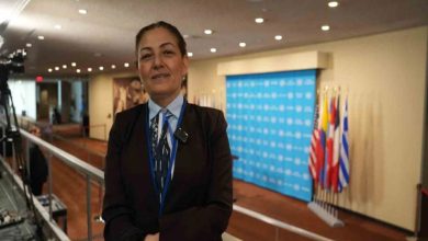 Milletvekili Fatma Öncü, toplantı salonunda ayakta durarak poz veriyor.