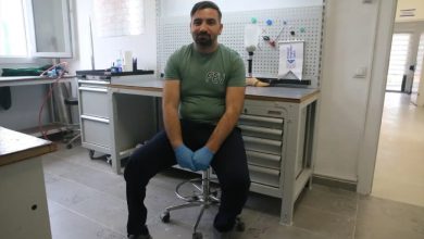 Ortez-protez teknikeri Mehmet Karakaş, çalıştığı kurumda ofis taburesinde oturarak poz veriyor.