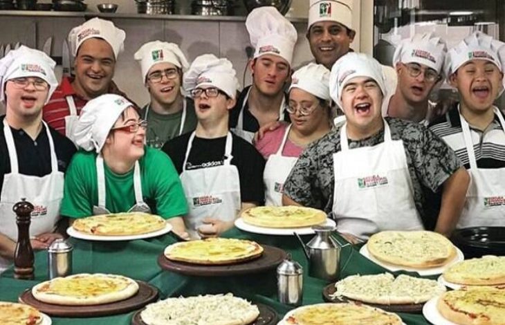 Beyaz mutfak önlükleri ve aşçı kepleri takmış, aralarında Down sendromlu bireylerin de bulunduğu kalabalık bir ekip bir arada poz veriyor. Grup üyelerinin oldukça mutlu, güler yüzlü ve enerjik oldukları görülüyor.