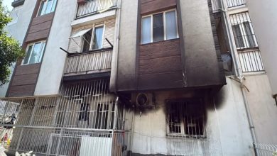 Alt katında yangın çıkmış bir apartmanın dış cephesinde, pencerelerin etrafında yoğun is ve kararma izleri görülüyor.