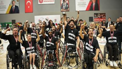 Beşiktaş Tekerlekli Sandalye Basketbol Takımı sporcuları kupayla sevinerek poz veriyor.