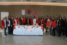 Dünya Otizm Farkındalık Günü kapsamında İzmir Şehir Hastanesi’nde açılan stantta doktorlar, personel ve katılımcılar toplu poz veriyor.