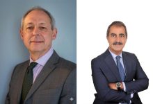 Görselde yan yana yerleştirilmiş iki erkek portresi bulunuyor. Soldaki kişi açık renk bir arka plan önünde, gri takım elbise ve yeşil tonlarında kravatla poz vermiş. Saçları seyrek ve kısa, yüzünde sakin ve ciddi bir ifade var. Doğrudan kameraya bakıyor ve daha klasik, resmi bir duruş sergiliyor. Sağdaki kişi ise beyaz arka plan önünde, koyu renk takım elbise ve kravatla, kollarını çapraz yapmış şekilde duruyor. Gür bıyığı ve daha belirgin yüz hatları dikkat çekiyor. Pozu daha kendinden emin ve güçlü bir duruş yansıtıyor.