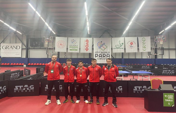 Milli sporcularımız Burak Burç ve Utku Caberoğlu, antrenörleri ile birlikte salonda poz veriyor.