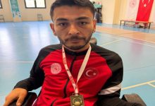 Engelli sporcu Yücel Coşkun, boynunda kazandığı madalyayla poz veriyor.