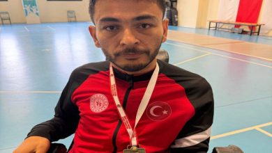 Engelli sporcu Yücel Coşkun, boynunda kazandığı madalyayla poz veriyor.