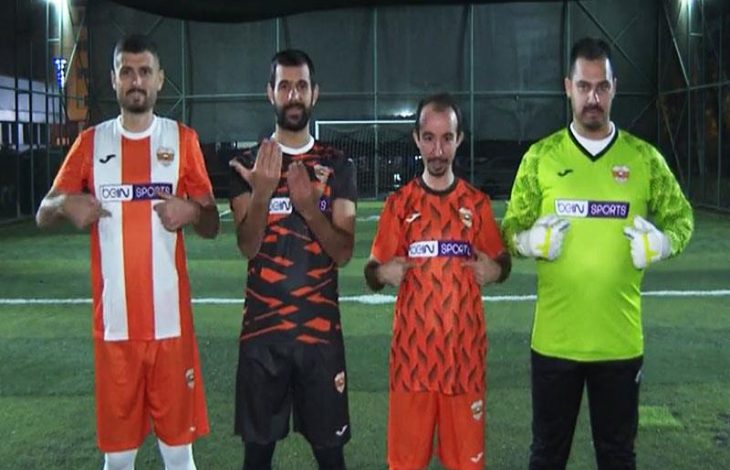 Yan yana sahada duran dört Adana İşitme Engelliler Spor Kulübü sporcusu, formalarında beIN SPORTS göğüs reklamı yazısını işaret ederek poz veriyor.