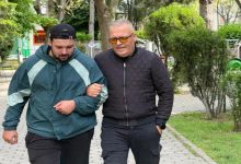 Görme engelli Yasin Kurt, koluna girdiği genç bir erkek ile geziyor.