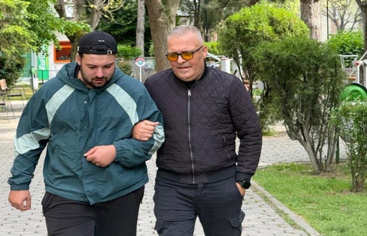 Görme engelli Yasin Kurt, koluna girdiği genç bir erkek ile geziyor.