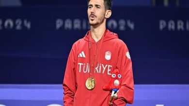 Para tekvandocu Mahmut Bozteke kazandığı altın madalya ile İstiklâl Marşını okuyor.