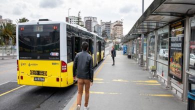 Metrobüs durağında çekilen fotoğrafta, sarı renkli bir metrobüs peronda yolcu indirirken bir kişi durağa doğru yürüyerek araca yaklaşmaya çalışıyor. Uzun ve geniş peron alanında durak yapıları, reklam panoları ve şehir binaları arka planda görülüyor. Görsel, toplu taşımada özellikle engelli bireylerin erişim ve ulaşım sırasında karşılaştığı zorluklara dikkat çeken bir atmosfer yansıtıyor.