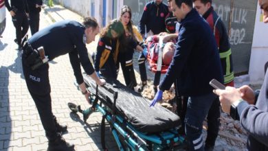 Sağlık ekipleri ve polis memurları hastayı sedyeye taşıyor.