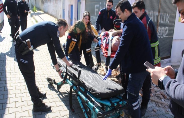Sağlık ekipleri ve polis memurları hastayı sedyeye taşıyor.