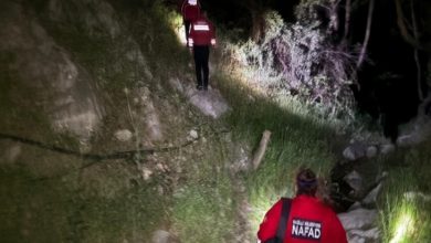 Gece vakti, engebeli ve bitki örtüsüyle kaplı bir arazide ilerleyen iki arama-kurtarma görevlisi görülüyor. Kırmızı kıyafetlerinde “NAFAD” yazısı var. Ellerindeki ışıklarla patikayı aydınlatıyorlar; ortam acil bir arama çalışması izlenimi veriyor.