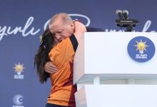 Down sendromlu kız çocuğu kürsünün yanında Cumhurbaşkanı Recep Tayyip Erdoğan'a sarılıyor.