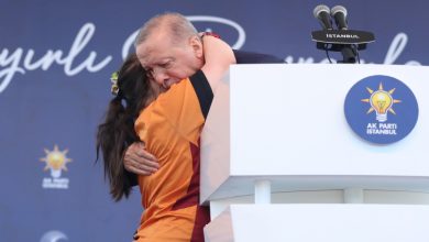 Down sendromlu kız çocuğu kürsünün yanında Cumhurbaşkanı Recep Tayyip Erdoğan'a sarılıyor.