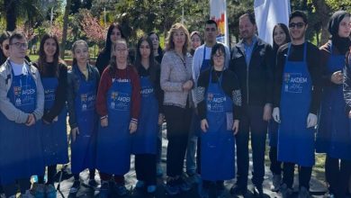 Engelli bireylerle üniversite öğrencileri yeşil bir alanda hatıra pozu veriyor.
