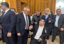 TBMM’de düzenlenen toplantı sırasında çekilen fotoğrafta, takım elbiseli kalabalık bir grup ayakta sohbet ediyor. Ön planda tekerlekli sandalyedeki bir erkek ile bir milletvekili tokalaşarak konuşurken görülüyor. Fotoğraf, Engelliler Haftası kapsamında Meclis’te gerçekleşen buluşmanın samimi ve yoğun atmosferini yansıtıyor.