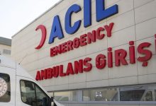 Bir hastanenin acil girişinde beyaz bir ambulans duruyor.