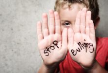 Görselde, ellerini kameraya doğru uzatan bir çocuk yer alıyor. Avuç içlerine İngilizce "Stop Bullying" (Zorbalığı Durdurun) yazılmış. Fotoğraf, çocuklara yönelik akran zorbalığına dikkat çeken güçlü ve çarpıcı bir mesaj veriyor.