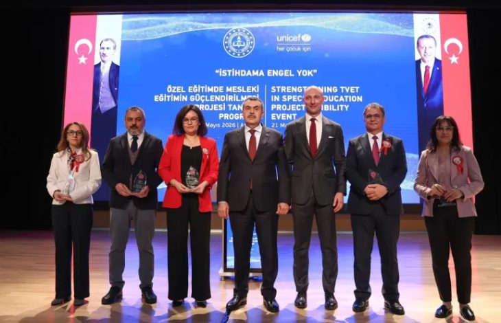 Milli Eğitim Bakanı Yusuf Tekin, UNICEF Türkiye Temsilcisi Paolo Marchi ve ellerinde plaket tutan katılımcılar yan yana sahnede bulunuyor.