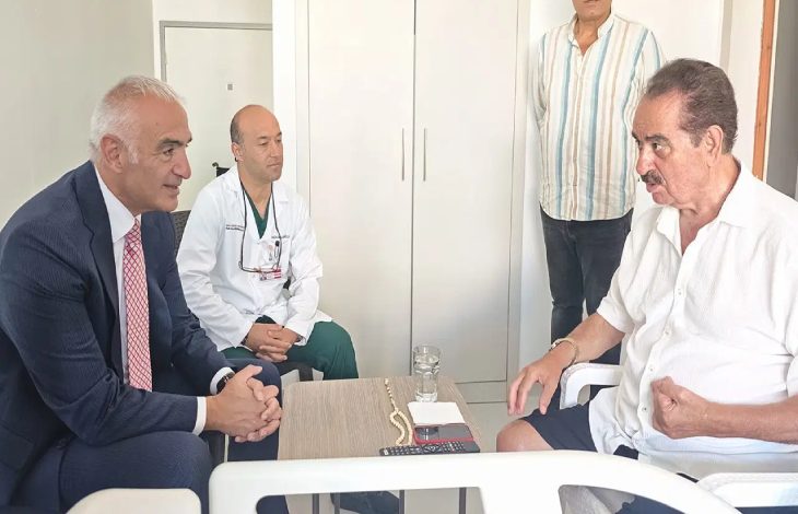 Kültür ve Turizm Bakanı Mehmet Nuri Ersoy ile sanatçı İbrahim Tatlıses oturarak sohbet ederken, yanlarında Başhekim Prof. Dr. Emre Adıgüzel bulunuyor.