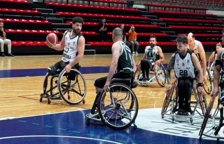 Maç anında top süren basketbolcuya markaj uygulanıyor ve diğer sporcular sahada bulunuyor.