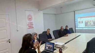 Görselde, bir toplantı salonunda gerçekleştirilen eğitim programı görülüyor. Masanın etrafında oturan katılımcılar, projeksiyon cihazıyla yansıtılan sunumu takip ediyor. Salonda bulunan afişte, programın T.C. Bilecik Aile ve Sosyal Hizmetler İl Müdürlüğü tarafından düzenlendiği anlaşılıyor. Eğitim ortamında bilgilendirme ve farkındalık çalışması yapıldığı görülüyor.